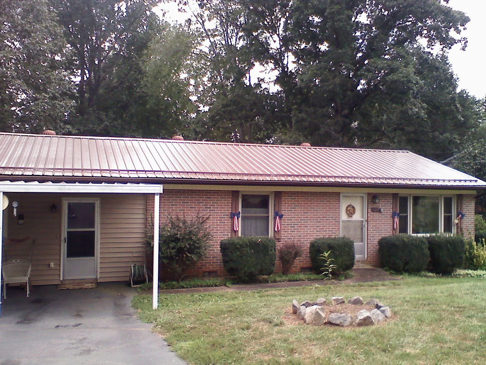 Bronze metal roof and carport on a brick ranch home — Roof Repair work by our crew in Rainsville