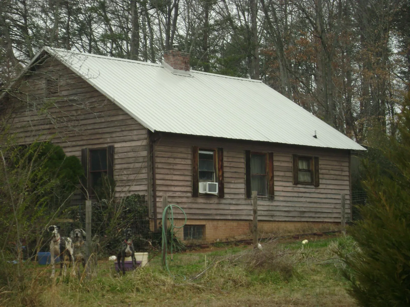 White metal roof on an old wood sided farmhouse, from a Metal Roof Installation job in Rainsville